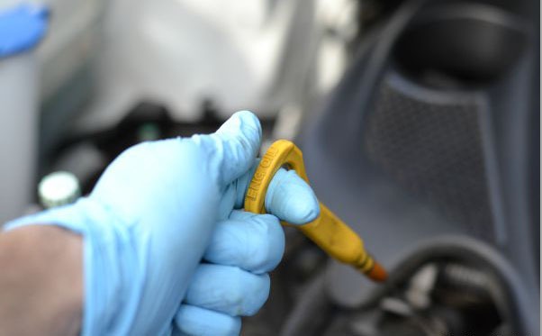 How to change oil - dipstick being pulled out of engine.