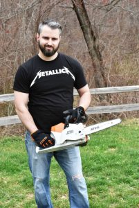 man holding battery powered Stihl chainsaw