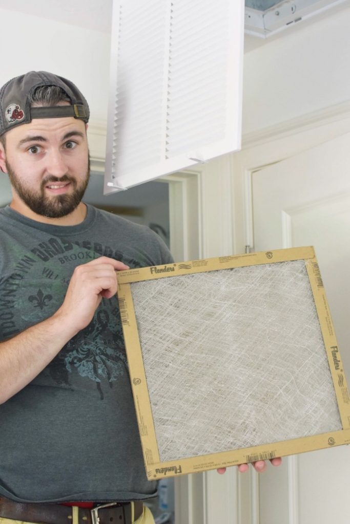 man holding dirty air filter