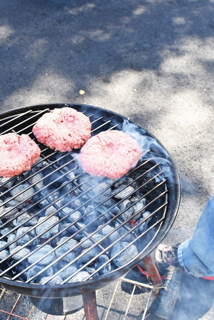 hamburger patties on a charcoal grill