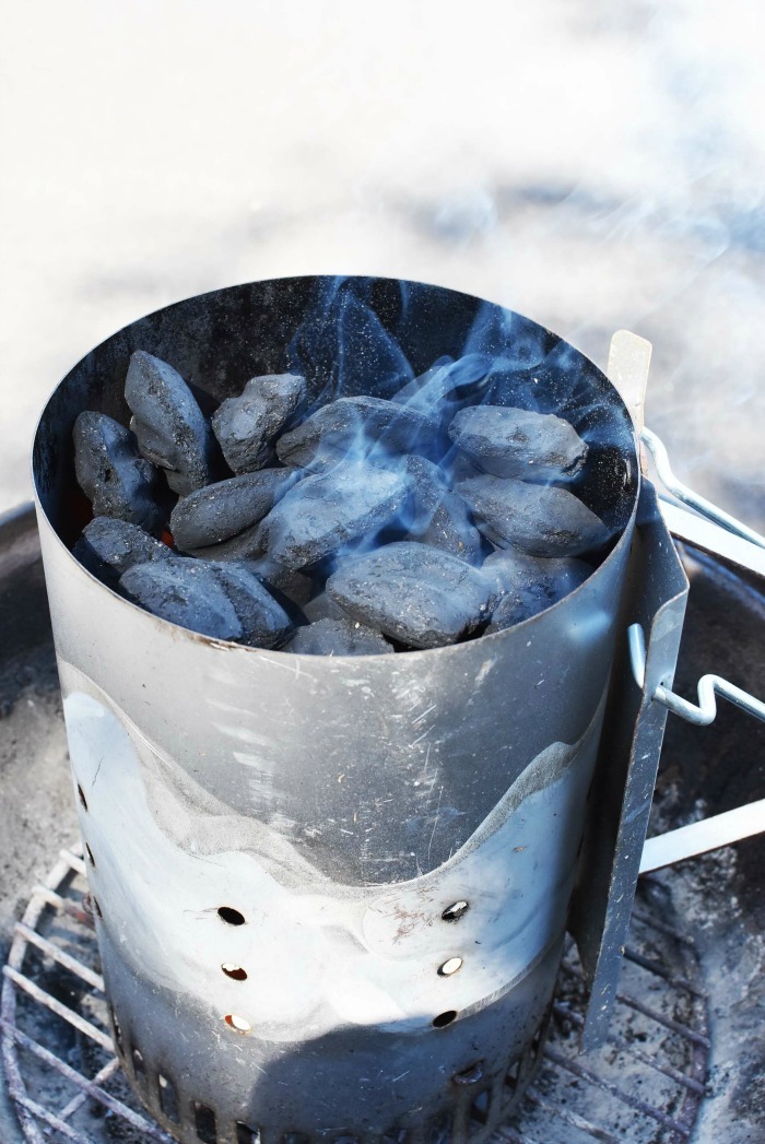 charcoal briquettes smoking inside of a chimney