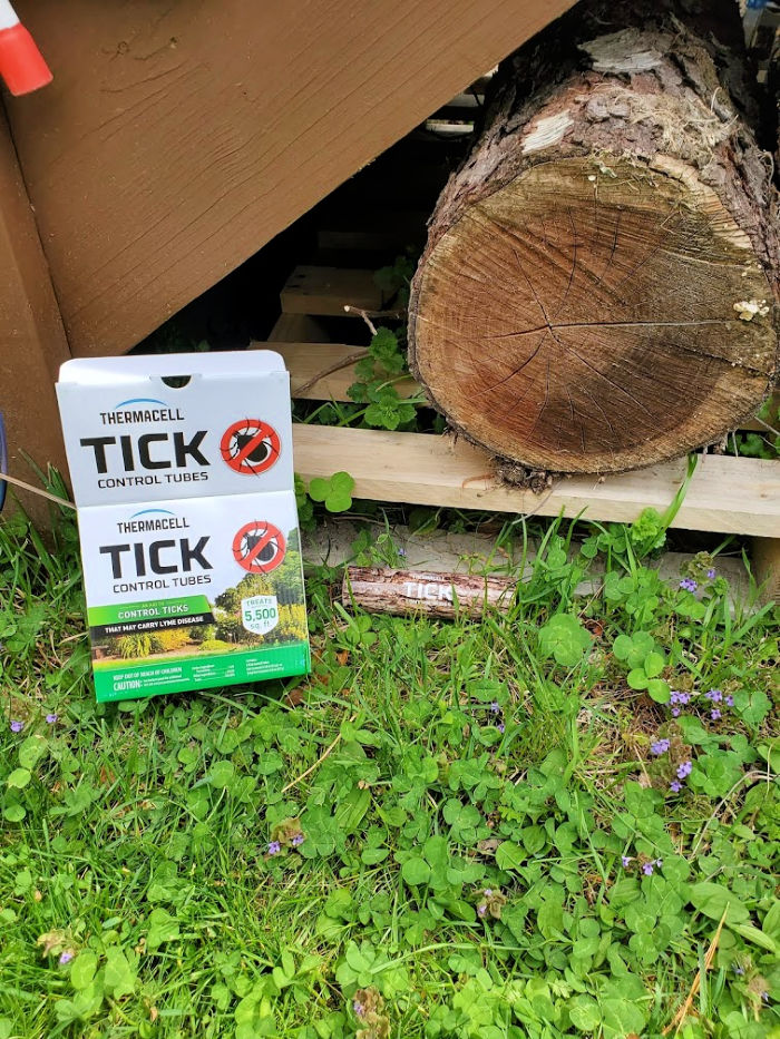 Thermacell Tick Control Tubes count of 6 box on grass. Tube on grass under a pallet. log on a pallet.