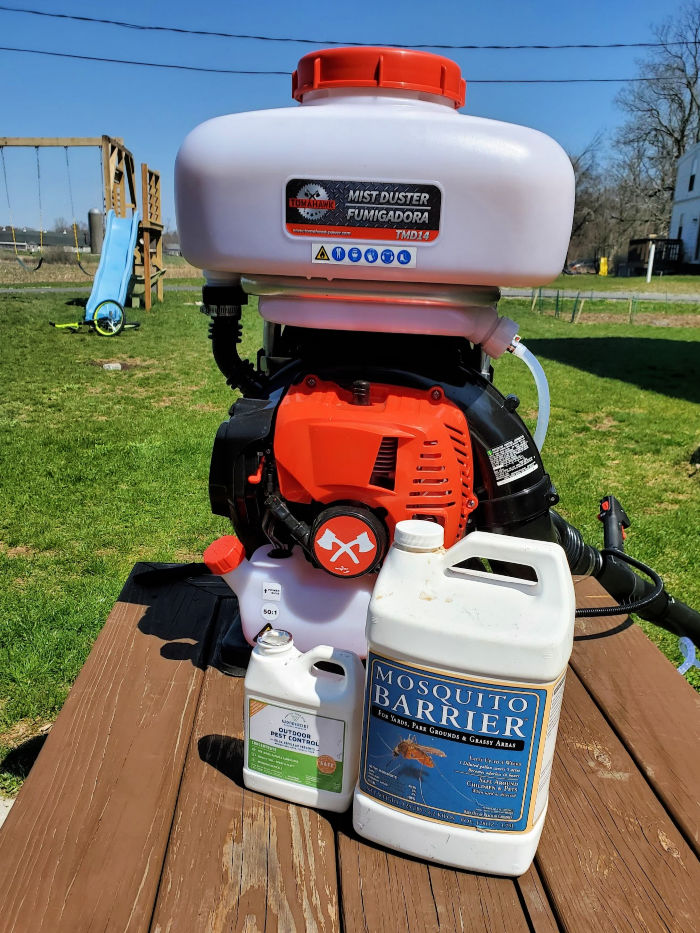 gas backpack sprayer and chemicals on bench